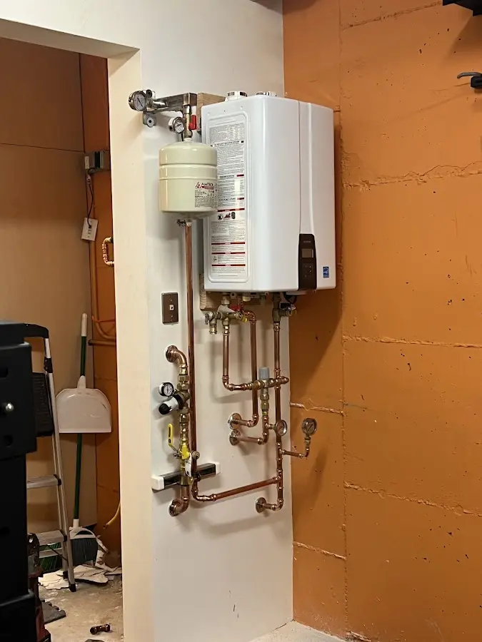 Plumbing technician inspecting water heater connections in Upper Saddle River